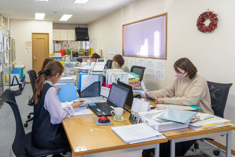 デスクワークを行う5名のスタッフ